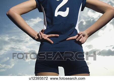 Woman in athletic gear with hands behind back View Large Photo Image Stock Image - Woman in athletic gear with hands behind back. Fotosearch