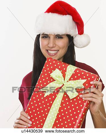 Stock Photo - Woman in Santa Claus hat holding gift. Fotosearch