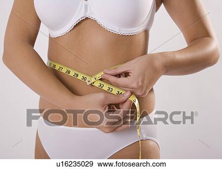 Woman in underwear measuring waist View Large Photo Image Stock Photo - Woman in underwear measuring waist. Fotosearch