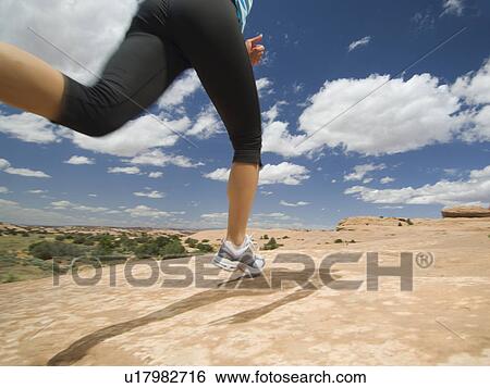 Stock Photograph - Woman jogging in desert. Fotosearch
