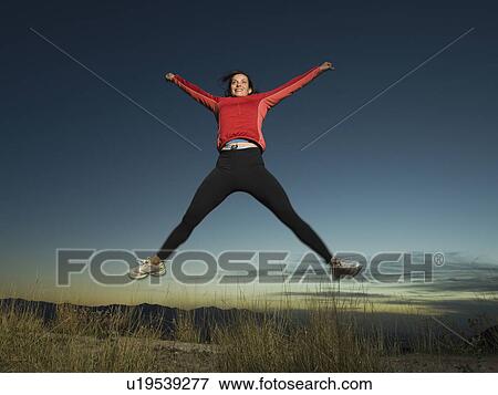 Woman jumping with arms raised, Salt Flats, Utah, United States View Large Photo Image Stock Photo - Woman jumping with arms raised, Salt Flats, Utah, United States. Fotosearch