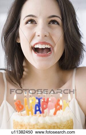 Woman laughing next to birthday cake View Large Photo Image Stock Image - Woman laughing next to birthday cake. Fotosearch