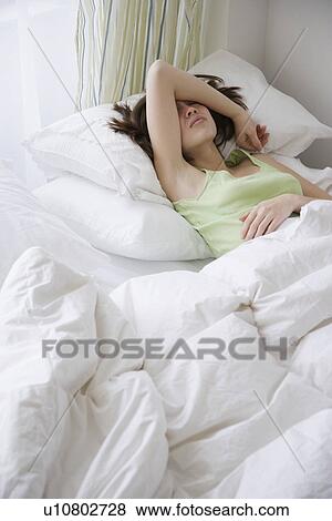 Woman laying in bed View Large Photo Image Stock Photo - Woman laying in bed. Fotosearch