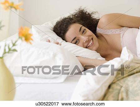 Stock Photo - Woman laying in bed. Fotosearch