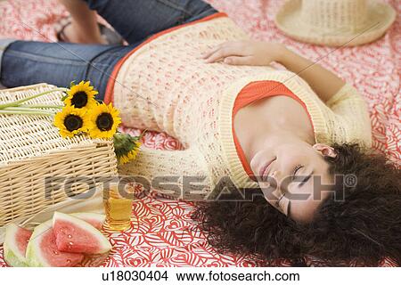 Woman laying on picnic blanket View Large Photo Image Picture - Woman laying on picnic blanket. Fotosearch