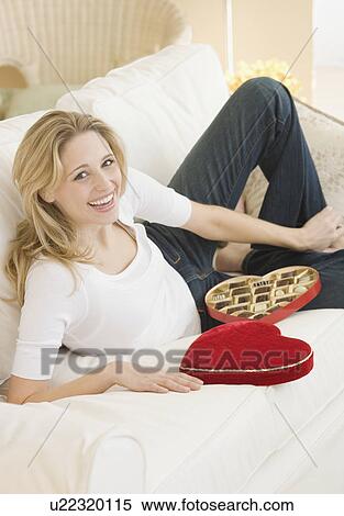 Woman laying on sofa with box of candy View Large Photo Image Stock Photography - Woman laying on sofa with box of candy. Fotosearch