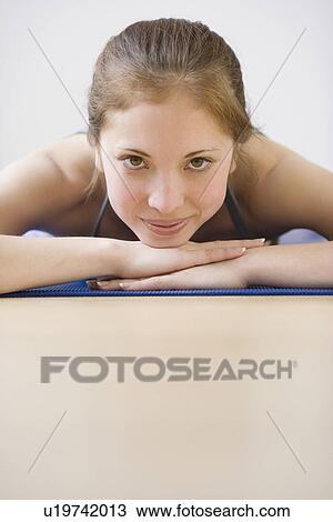 Stock Image - Woman laying on yoga mat. Fotosearch