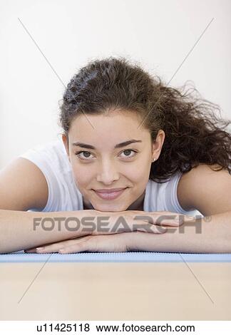 Woman laying on yoga mat View Large Photo Image Stock Photo - Woman laying on yoga mat. Fotosearch