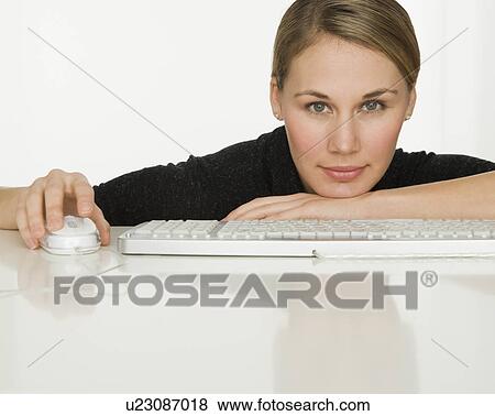 Woman leaning on table next to keyboard View Large Photo Image Stock Photo - Woman leaning on table next to keyboard. Fotosearch