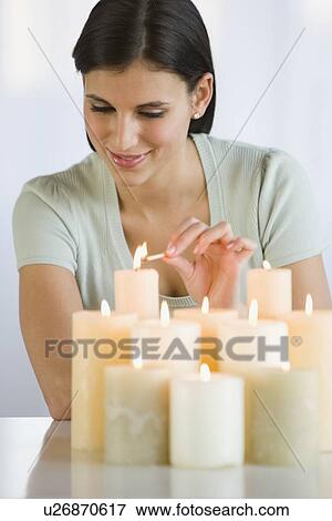 Stock Photo - Woman lighting candles. Fotosearch