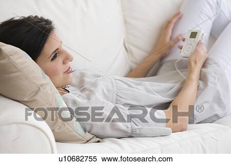Stock Photography - Woman listening to mp3 player. Fotosearch