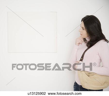 Woman looking at blank picture on wall View Large Photo Image Stock Image - Woman looking at blank picture on wall. Fotosearch