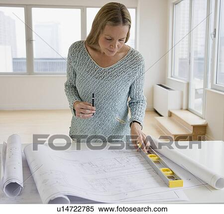 Stock Photography - Woman looking at blueprints. Fotosearch