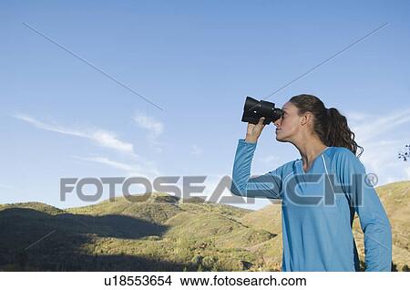 Woman looking through binoculars, Utah, United States View Large Photo Image Picture - Woman looking through binoculars, Utah, United States. Fotosearch
