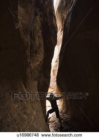 Stock Photo - Woman looking up between rock formations. Fotosearch