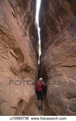 Woman looking up between rock formations View Large Photo Image Stock Photograph - Woman looking up between rock formations. Fotosearch