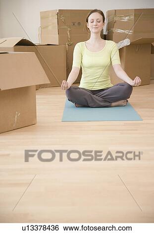Woman meditating in new house View Large Photo Image Stock Photograph - Woman meditating in new house. Fotosearch