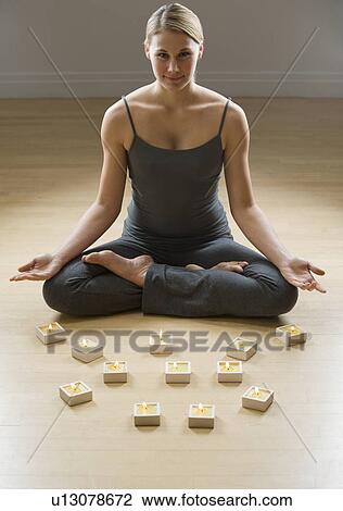 Woman meditating next to candles View Large Photo Image Stock Image - Woman meditating next to candles. Fotosearch