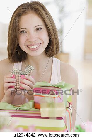 Stock Image - Woman next to stack of gifts. Fotosearch