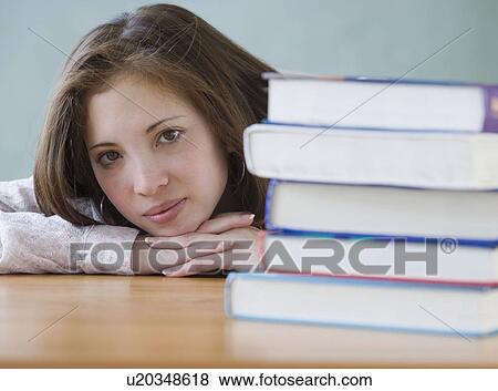 Stock Photo - Woman next to stack of school books. Fotosearch