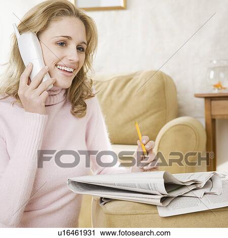 Woman on telephone with newspaper View Large Photo Image Stock Image - Woman on telephone with newspaper. Fotosearch