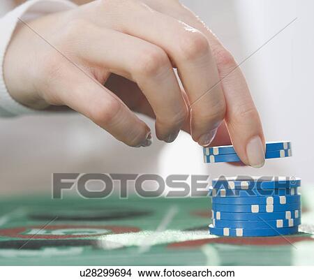 Picture - Woman picking up poker chips. Fotosearch