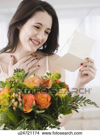 Woman reading card on flower bouquet View Large Photo Image Picture - Woman reading card on flower bouquet. Fotosearch