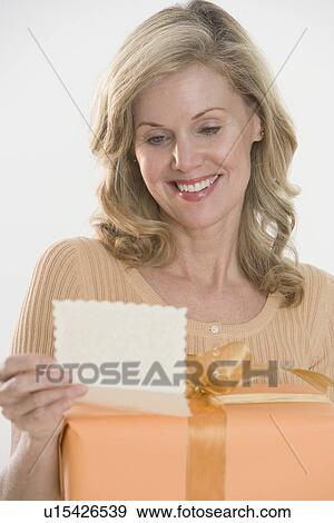 Woman reading card on gift View Large Photo Image Stock Photo - Woman reading card on gift. Fotosearch