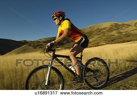 Stock Photo - Woman riding mountain bike, Salt Flats, Utah, United States. Fotosearch