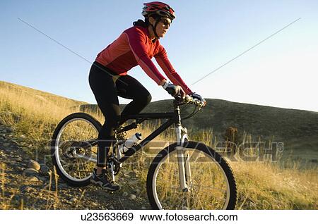 Stock Photo - Woman riding mountain bike, Salt Flats, Utah, United States. Fotosearch
