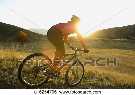 Stock Photograph - Woman riding mountain bike, Salt Flats, Utah, United States. Fotosearch