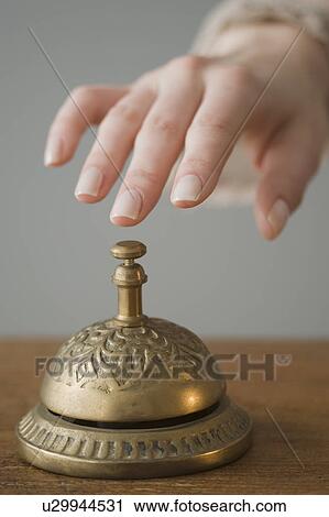 Stock Image - Woman ringing service bell. Fotosearch