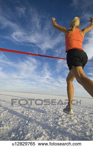 Stock Photography - Woman running across finish line, Utah, United States. Fotosearch