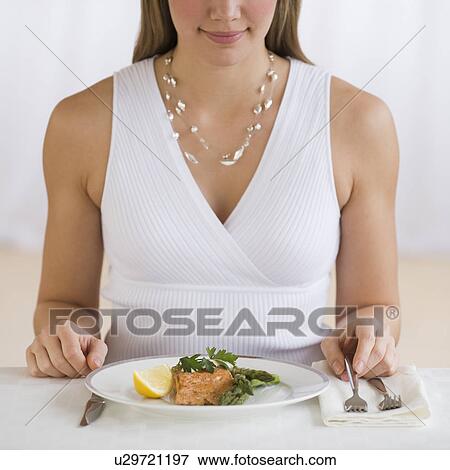 Woman sitting at dinner table View Large Photo Image Stock Photo - Woman sitting at dinner table. Fotosearch