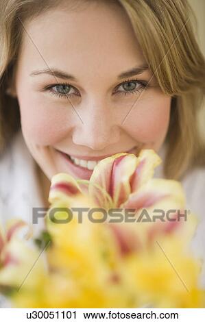 Stock Image - Woman smelling flower. Fotosearch
