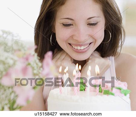 Stock Photo - Woman smiling at birthday cake. Fotosearch