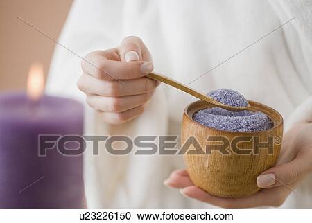 Stock Image - Woman spooning bath salts. Fotosearch