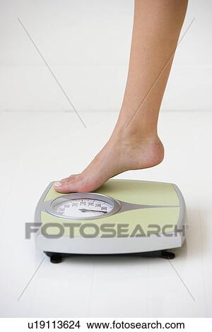 Woman stepping on scale View Large Photo Image Picture - Woman stepping on scale. Fotosearch