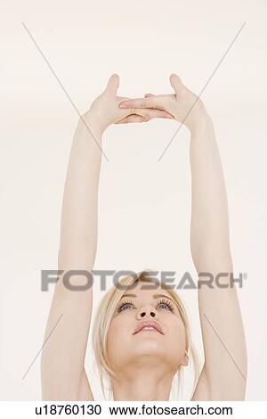 Stock Image - Woman stretching hands over head. Fotosearch