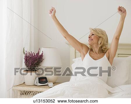 Woman stretching in bed View Large Photo Image Stock Image - Woman stretching in bed. Fotosearch
