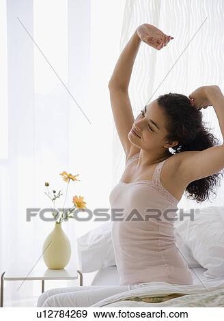 Woman stretching on bed View Large Photo Image Stock Photo - Woman stretching on bed. Fotosearch