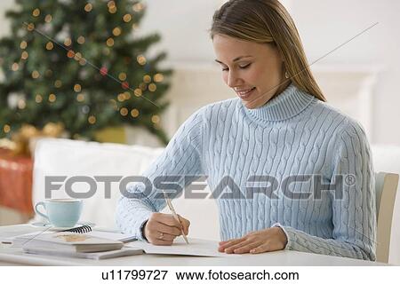 Stock Photo - Woman writing at desk. Fotosearch
