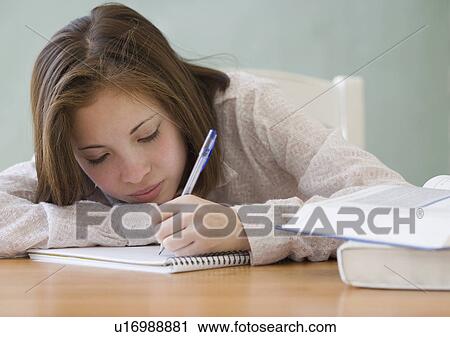 Stock Image - Woman writing in notebook. Fotosearch