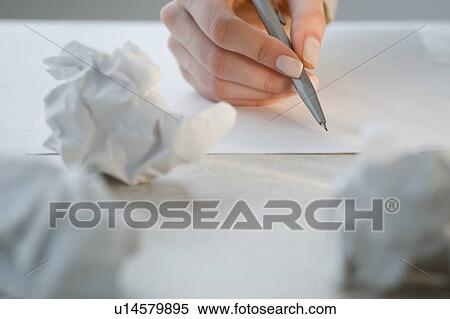 Stock Photography - Woman writing next to crumpled papers. Fotosearch