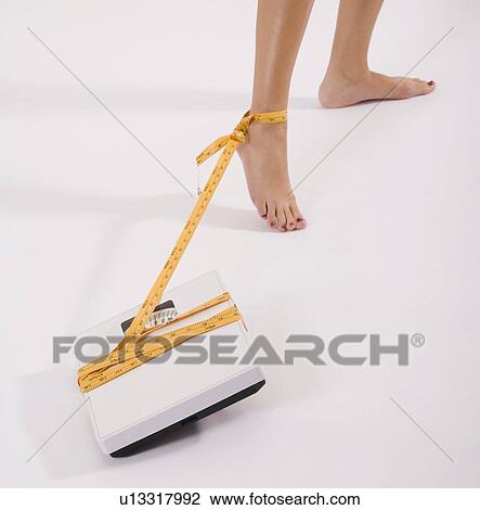 Woman’s foot tied to scale with tape measure View Large Photo Image Stock Image - Woman’s foot tied to scale with tape measure. Fotosearch