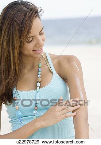 Women applying sunscreen View Large Photo Image Stock Photo - Women applying sunscreen. Fotosearch