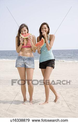 Women eating watermelon at beach View Large Photo Image Stock Photo - Women eating watermelon at beach. Fotosearch