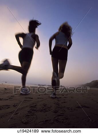 Stock Photo - Women jogging on beach. Fotosearch