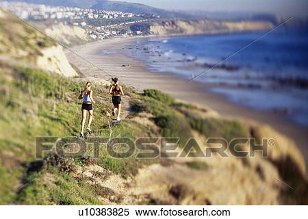 Women jogging on cliff along water View Large Photo Image Stock Photography - Women jogging on cliff along water. Fotosearch