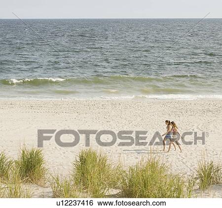 Women walking on beach View Large Photo Image Stock Photograph - Women walking on beach. Fotosearch